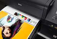 A freshly printed proof is in the printer's output tray.